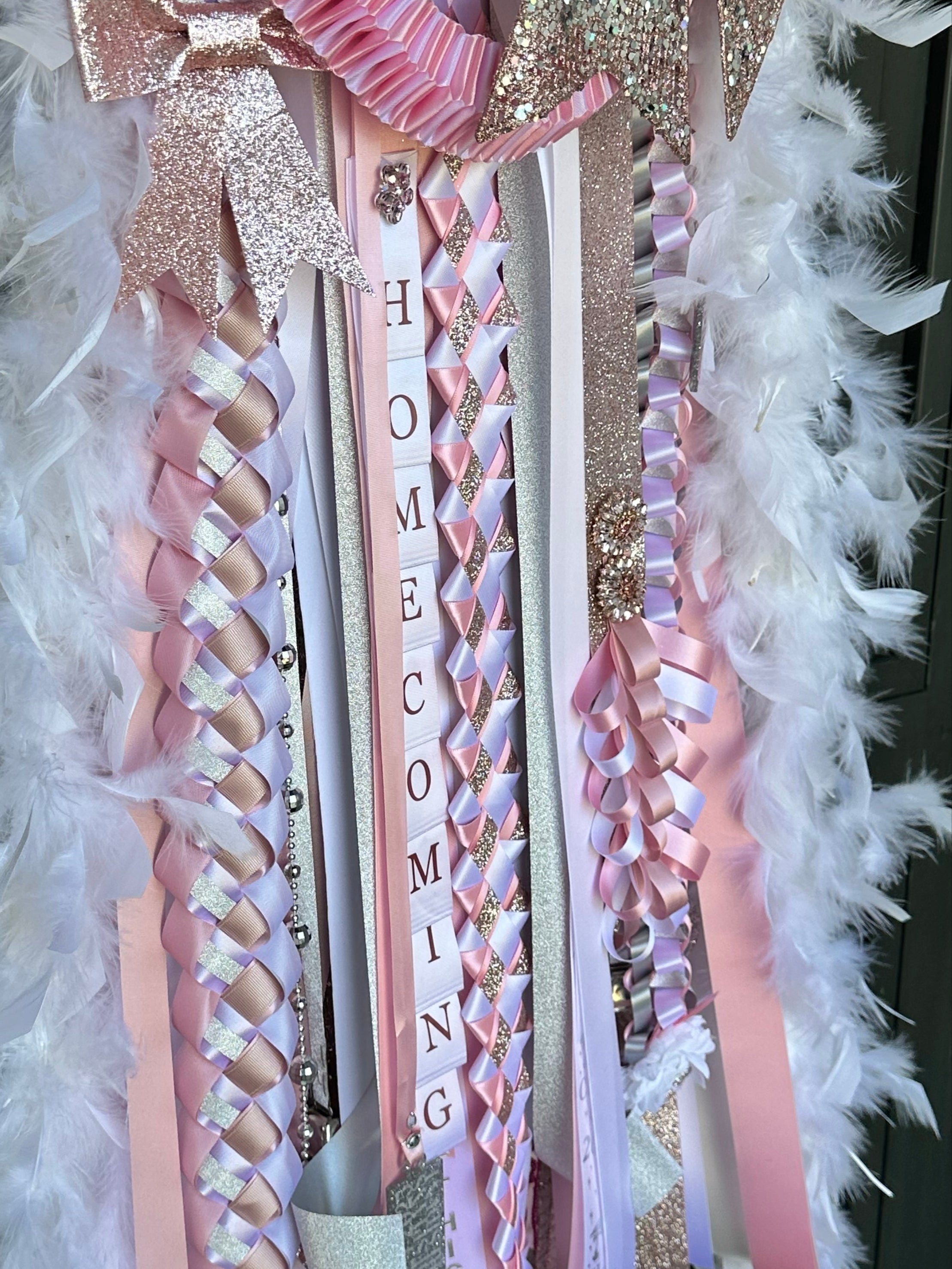 Decorative homecoming mum with ribbons and feathers on a dark background